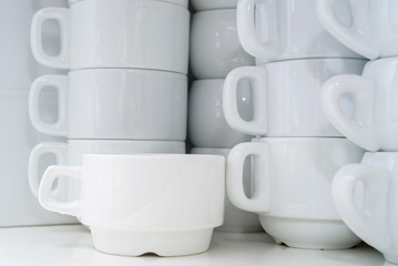 Stacked white clean cups in restaurant