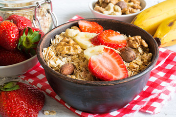bowl of homemade fruit muesli with strawberry, banana and nuts