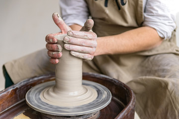 Hands working on pottery wheel