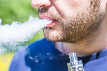 Adult man smoking a vape e-cigarette