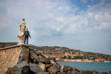 Jeune homme sur la digue du port de Porto Santo Stefano en Toscane