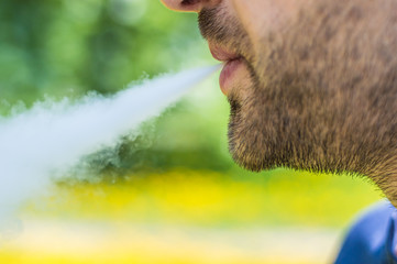 Adult man smoking a vape e-cigarette