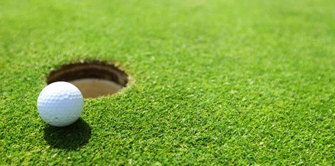 Tuinposter golfbal op lip van beker © yellowj