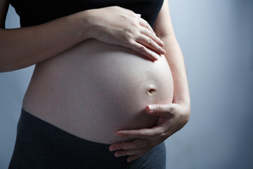 Young beautiful pregnant woman with hands on her belly