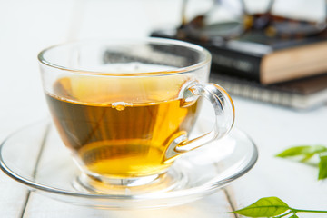 Cup of tea and book on white wooden table