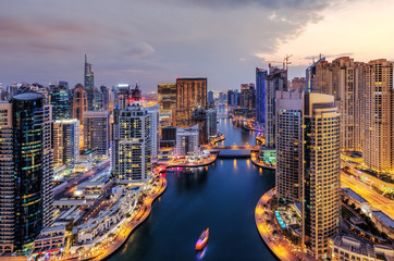 Fototapeta premium Spektakularny widok na duże, nowoczesne miasto nocą. Zatoka Dubai Marina z drapaczami chmur. Malownicza nocna panorama. Popularny cel podróży.
