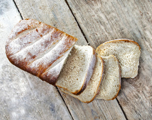 Sliced, white, and crusty bread loaf with rustic background.