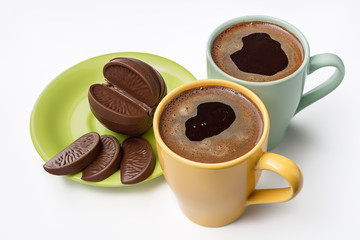Hot espresso, chocolate in the form of an orange on white