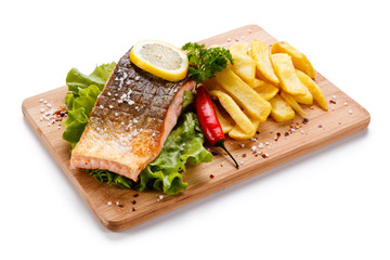 Grilled salmon with french fries on cutting board