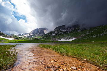 Mountain landscape with Pshekha-su mountain in gloomy cloud and Psenodah lake in the valley of Lagonaki, Caucasus, Russia
