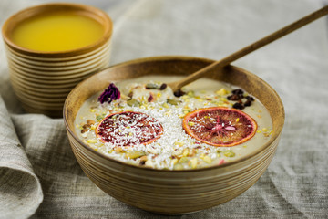 Healthy breakfast. Home made oatmeal porridge, goji berries, pumpkin and chia seeds in a ceramic bowl on white background.