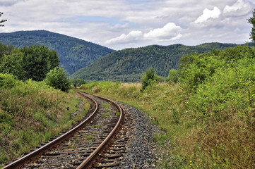 Railway track passes between the mountain