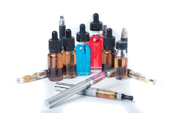 4 electronic cigarettes with glass e-liquid bottles and batteries on white background