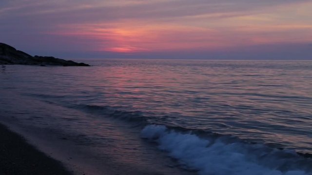Waves gently wash up onto the beach, then recede as the sunset. A beautiful sunset over a sea on Turkey akcakoca duzce