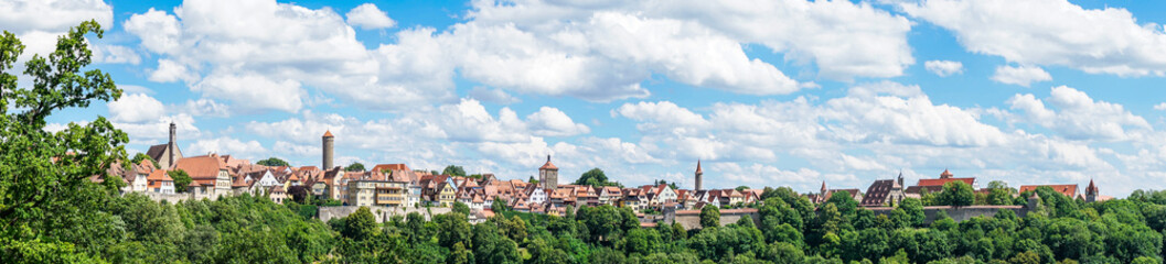 Fototapeta na wymiar Rothenburg ob der Tauber Skyline unter weiß-blauem Himmel als Panoramabild