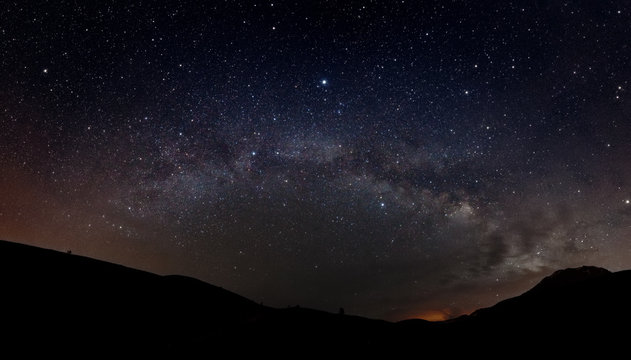 Starry sky with Milky way and silhouette of mountains