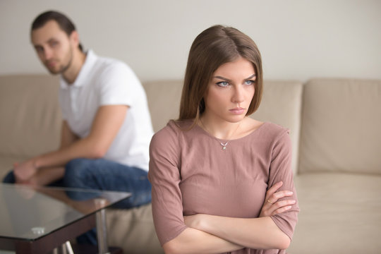 Angry frustrated woman with arms crossed, dissatisfied with bad husband behavior, cant stand it any longer, fed up, feeling affronted indignant, self-righteousness, couple after fight not talking