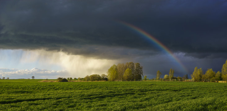 Rainbow in the sky above the spring field after the storm © Mike Mareen