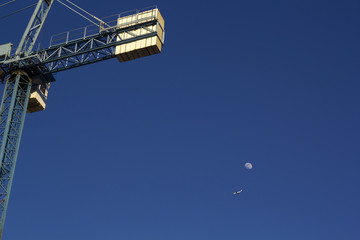 Sky with a crane, moon and a plane