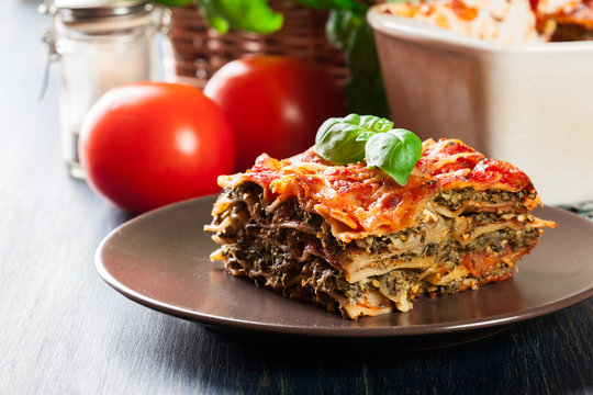 Piece of tasty hot lasagna with spinach on a plate