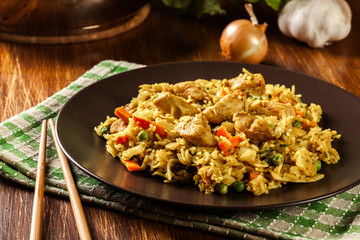 Fried rice nasi goreng with chicken and vegetables on a plate