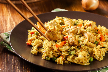 Fried rice nasi goreng with chicken and vegetables on a plate