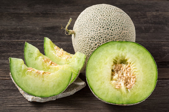ripe and fresh melon with sliced and half on old wooden table