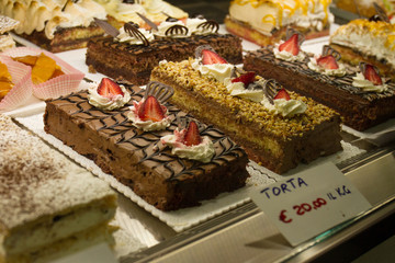 Tasty classic chocolate desserts cakes in restaurant shop window. Italian desserts. Italy, Sardinia.