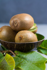 Fototapeta premium Tropical ripe organic kiwi fruit with leaves ready to eat