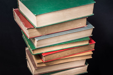 angle of depression, stacked old vintage books against dark background, close up