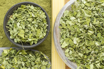 Leaves and moringa powder on wood (long moringa)