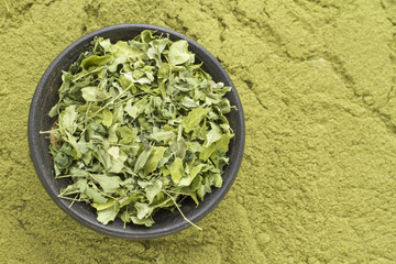 Leaves and moringa powder on wood (long moringa)
