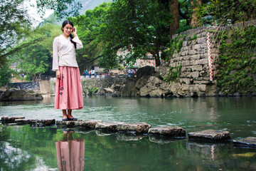 Girl walking on the stone bridge in the river