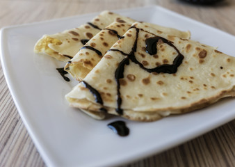 Dessert of pancakes on plate on table with eggs