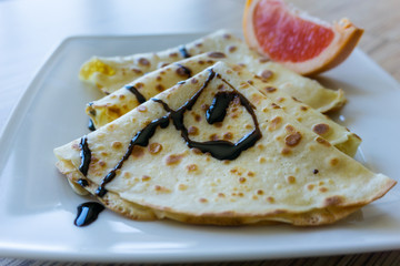 Dessert of pancakes on plate on table with eggs