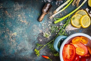 Healthy vegetarian eating and cooking with fresh organic vegetables and seasoning ingredients on dark rustic background, top view