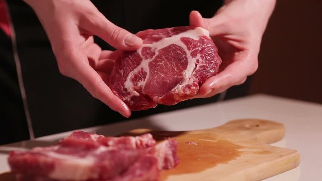 cut the meat of a black knife on black background. Do not want to cook in the kitchen, a wooden Board sharp meat. Beef, pork, meat.