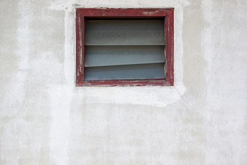 Broken window on concrete wall.