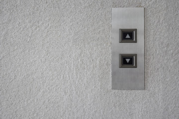 The modern lift button panel on stone tite wall close up background.