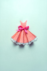 New dress / Creative concept photo of a dress with a bow made of paper on mint background.