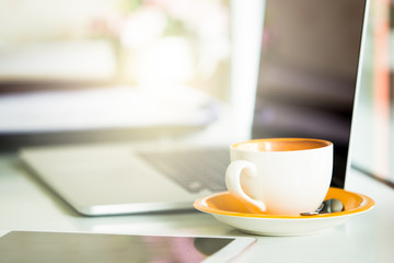Cup of coffee and smart devices on the table close up.
