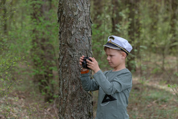 Fototapeta premium Young photographer in a pine forest with a camera
