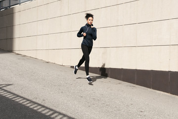 African American woman running in urban street