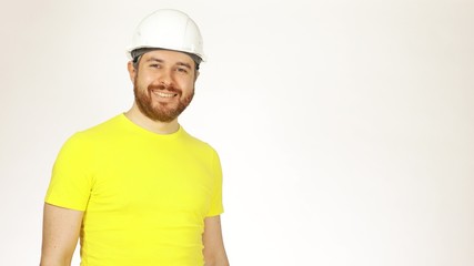 Portrait of handsome cheerful construction engineer or architect in yellow tshirt and hard hat...