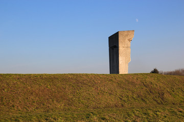 The concrete monument on the background of green grass and sky
