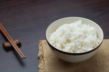 Thai rice with chopsticks on wood background