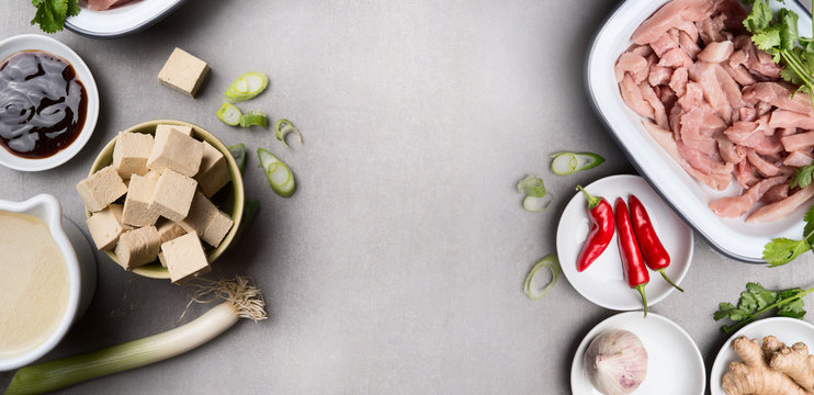 Asian Cooking Ingredients In Bowls With Tofu, Chili, Soy Sauce, Meat, Ginger And Broth On Gray Concrete Background, Top View, Banner. Asian Cuisine Concept