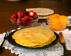Stack of sweet pancakes with cinnamon on a brown plate