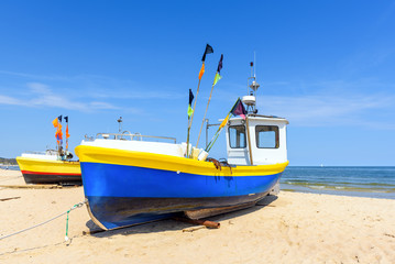 Naklejka na ściany i meble Colorful fishing boats on sandy Sopot beach in sunny day. Baltic sea, Pomerania. Poland