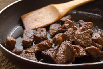 Fried beef goulash in a frying pan. Nutritious, tasty and low-fat dish.